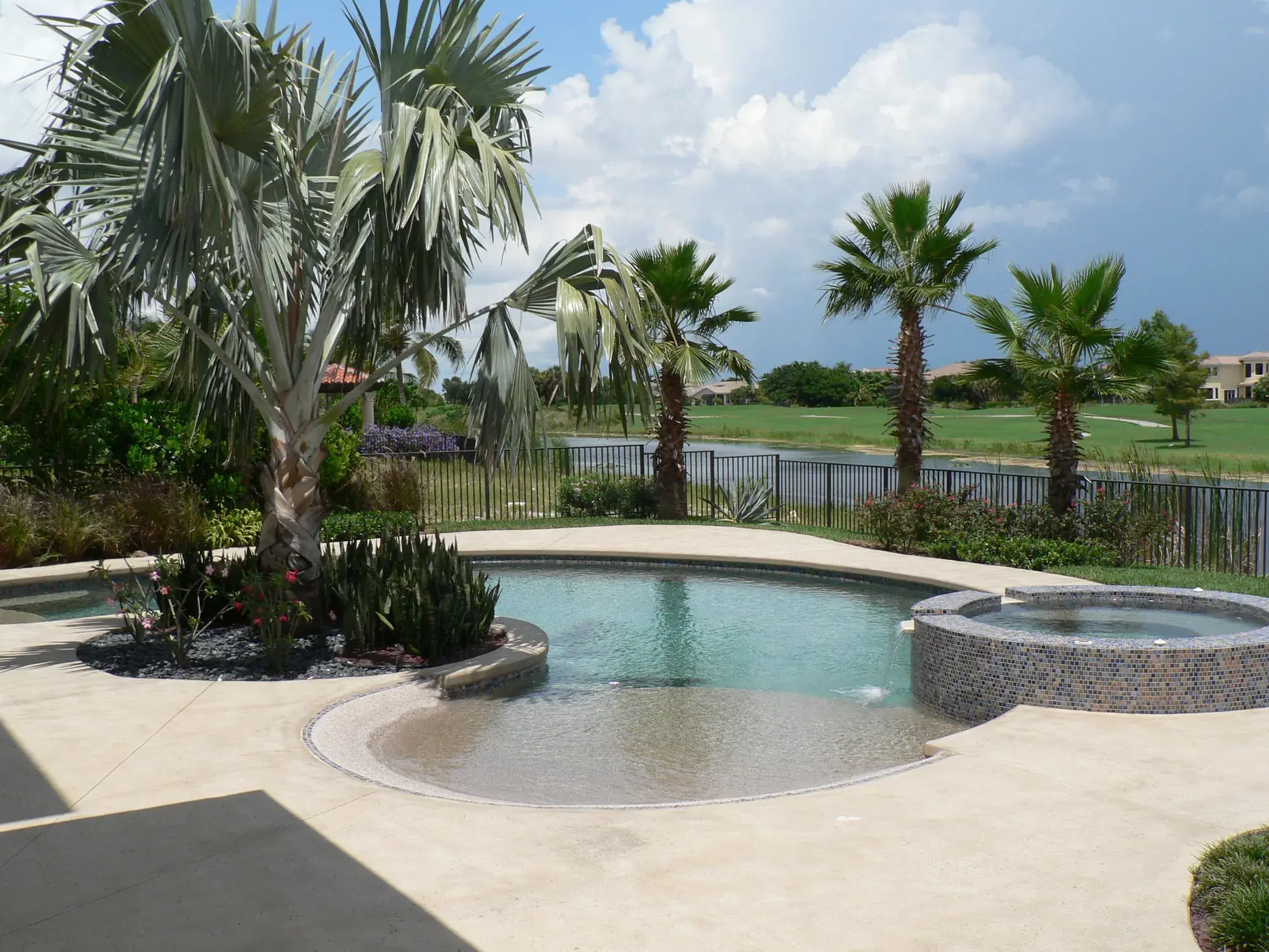 Freeform pool with beach entrance and travertine deck