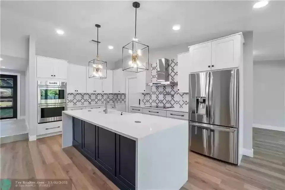Bright white kitchen with island seating and patterned tile backsplash