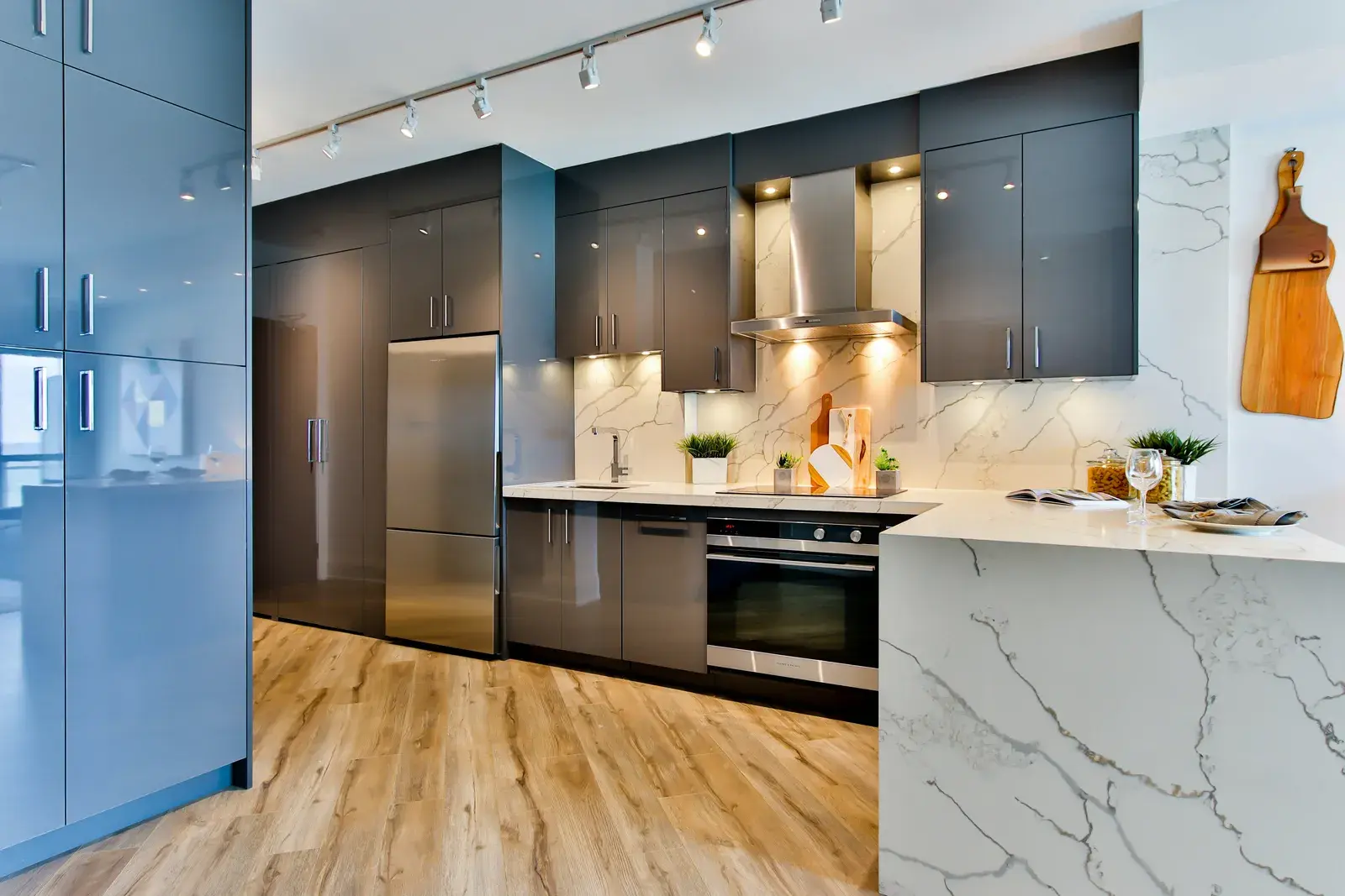 Contemporary kitchen with waterfall marble island and glass backsplash