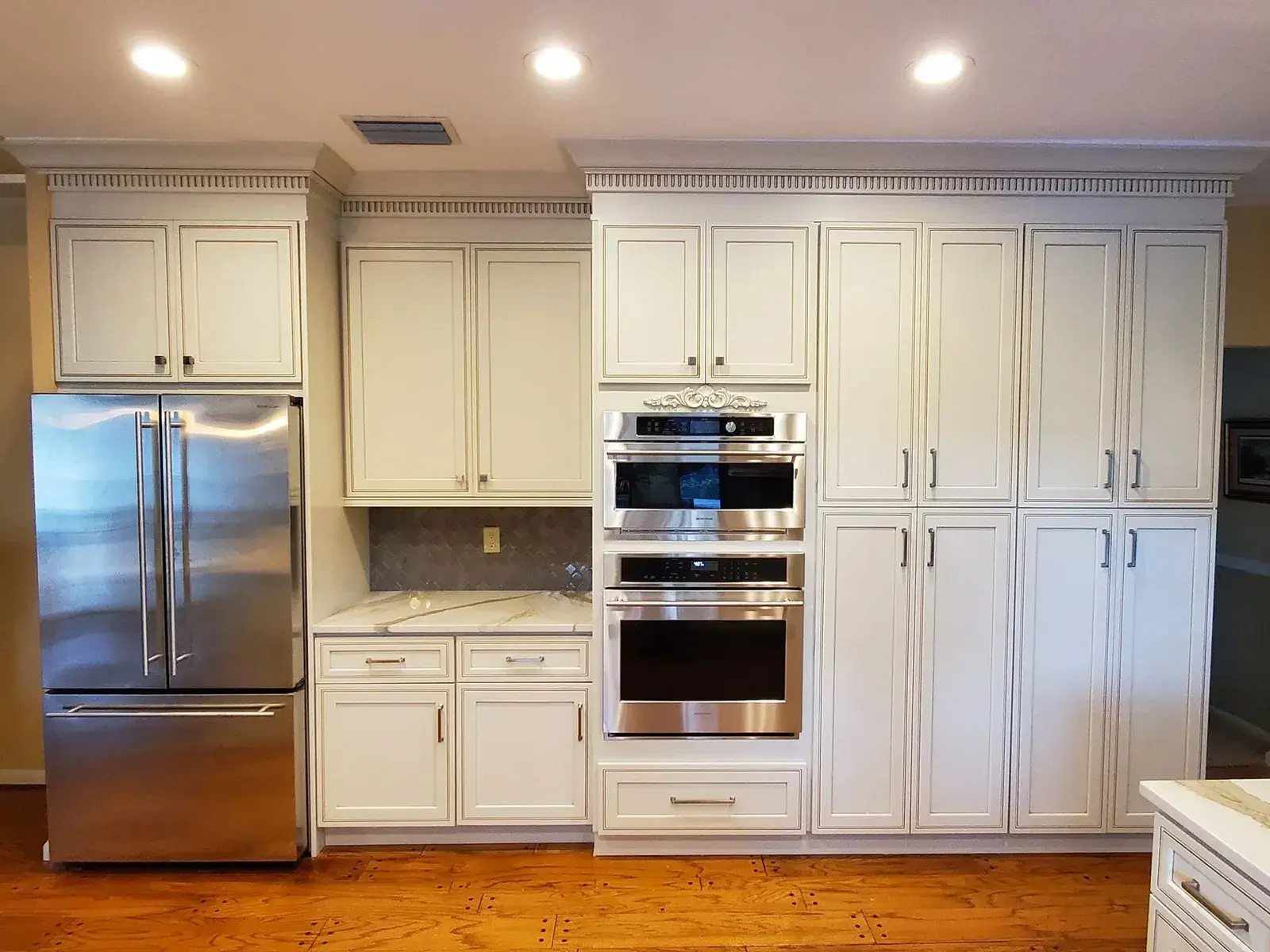 White cabinet kitchen with built-in double wall ovens
